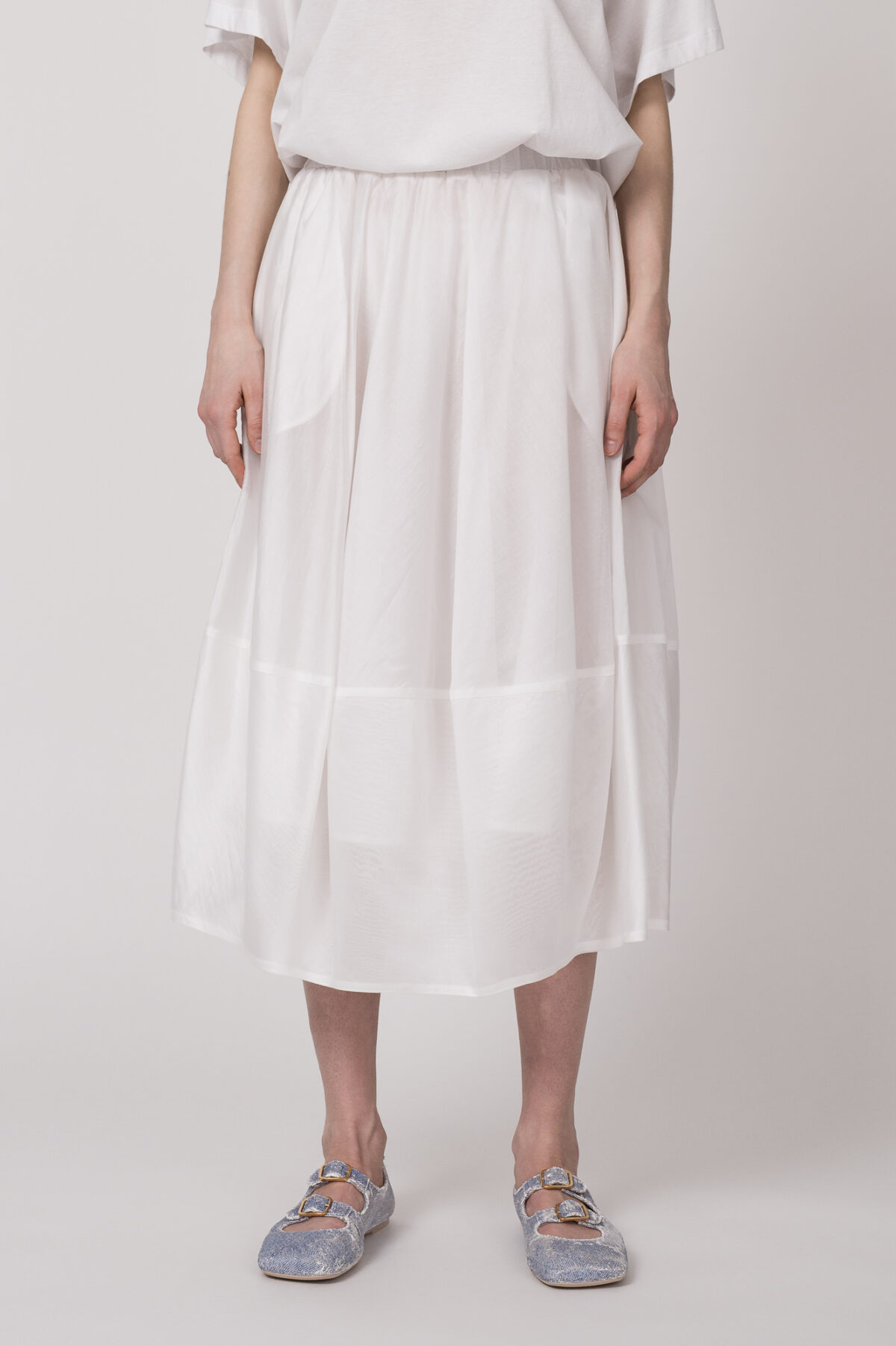 Model trägt einen weißen Rock der Marke Me iMeij.