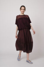 Model trägt ein bordeaux-farbiges Oberteil und einen bordeaux-farbigen Rock der Marke MeiMeij.