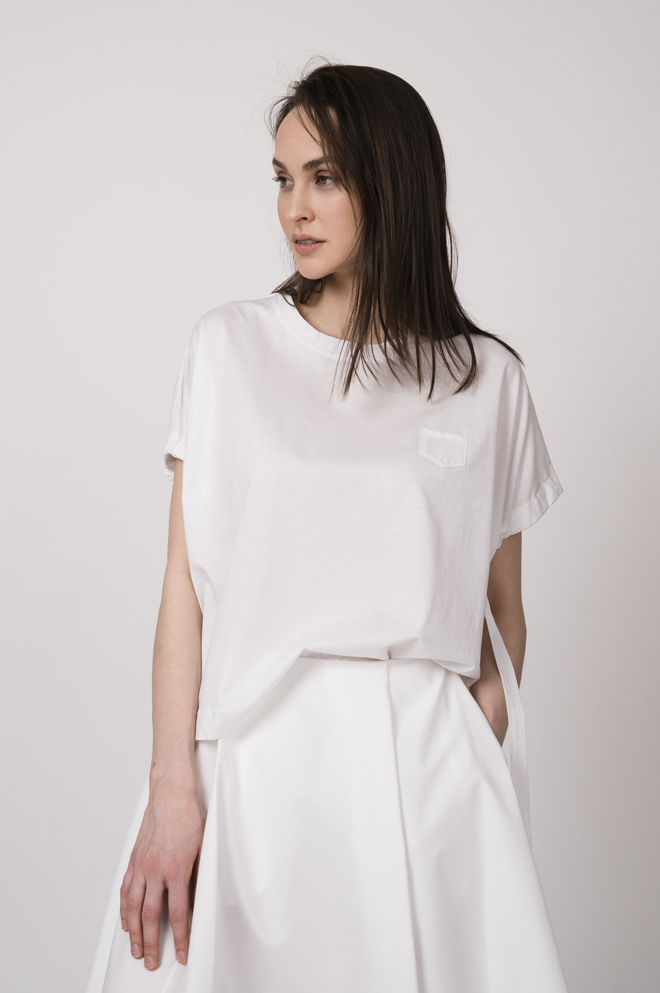 Model trägt ein weißes Oberteil der Marke MeiMeij.