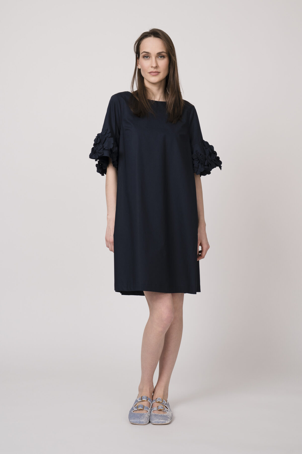 Model trägt ein marine-blaues Kleid mit Blumen-Ornamenten an den Ärmeln der Marke MeiMeij.