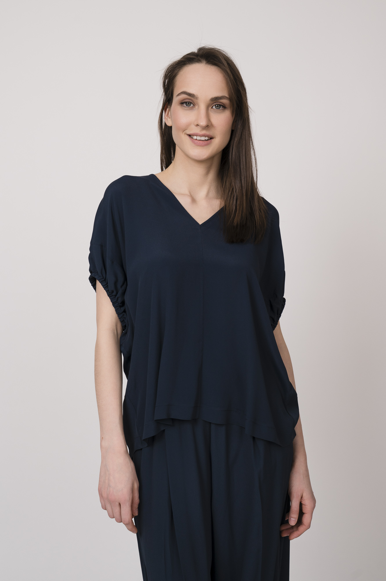 Model trägt ein marine-blaues Oberteil der Marke MeiMeij.