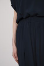 Model trägt eine marine-blaue Hose der Marke MeiMeij.