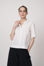 Model trägt eine weiße Kurzarmbluse der Marke Lis Lareida.