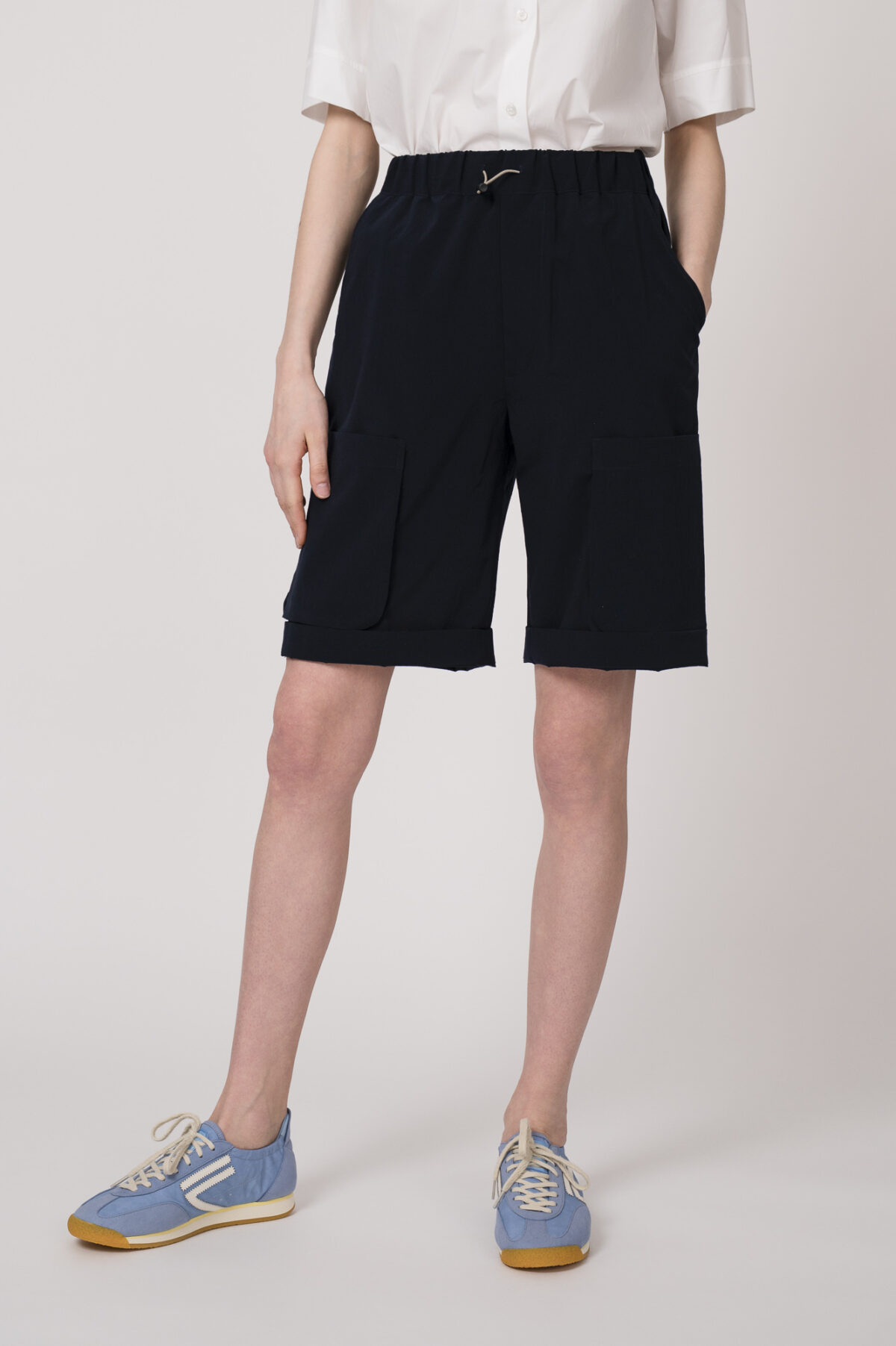 Model trägt eine marine-blaue Bermuda Shorts der Marke Lis Lareida.