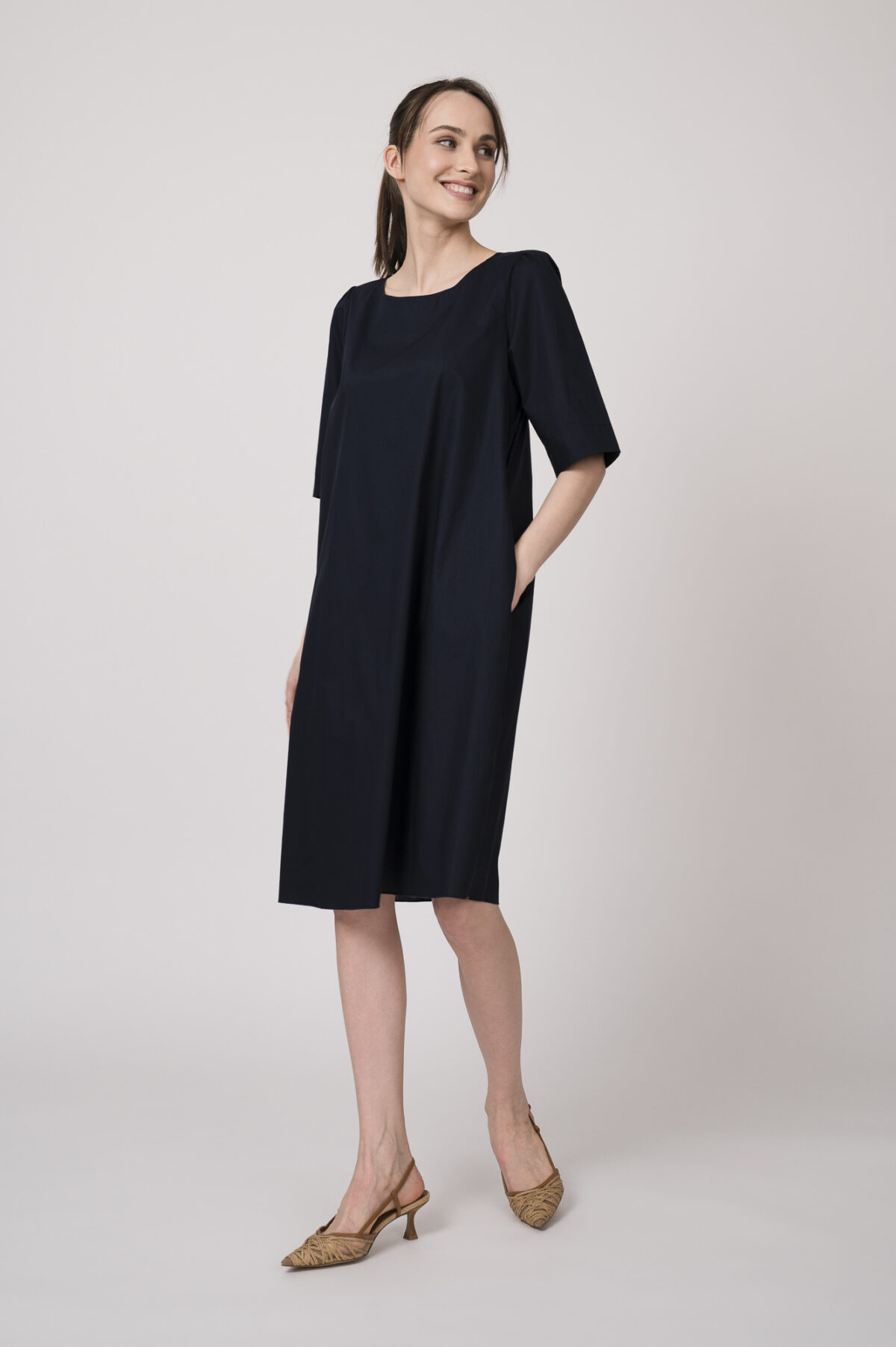 Model trägt ein marine-blaues Kleid der Marke Susanne Bommer.