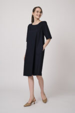 Model trägt ein marine-blaues Kleid der Marke Susanne Bommer.