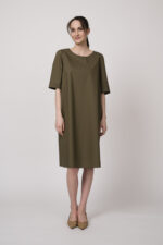 Model trägt ein oliv-grünes Kleid der Marke Susanne Bommer.