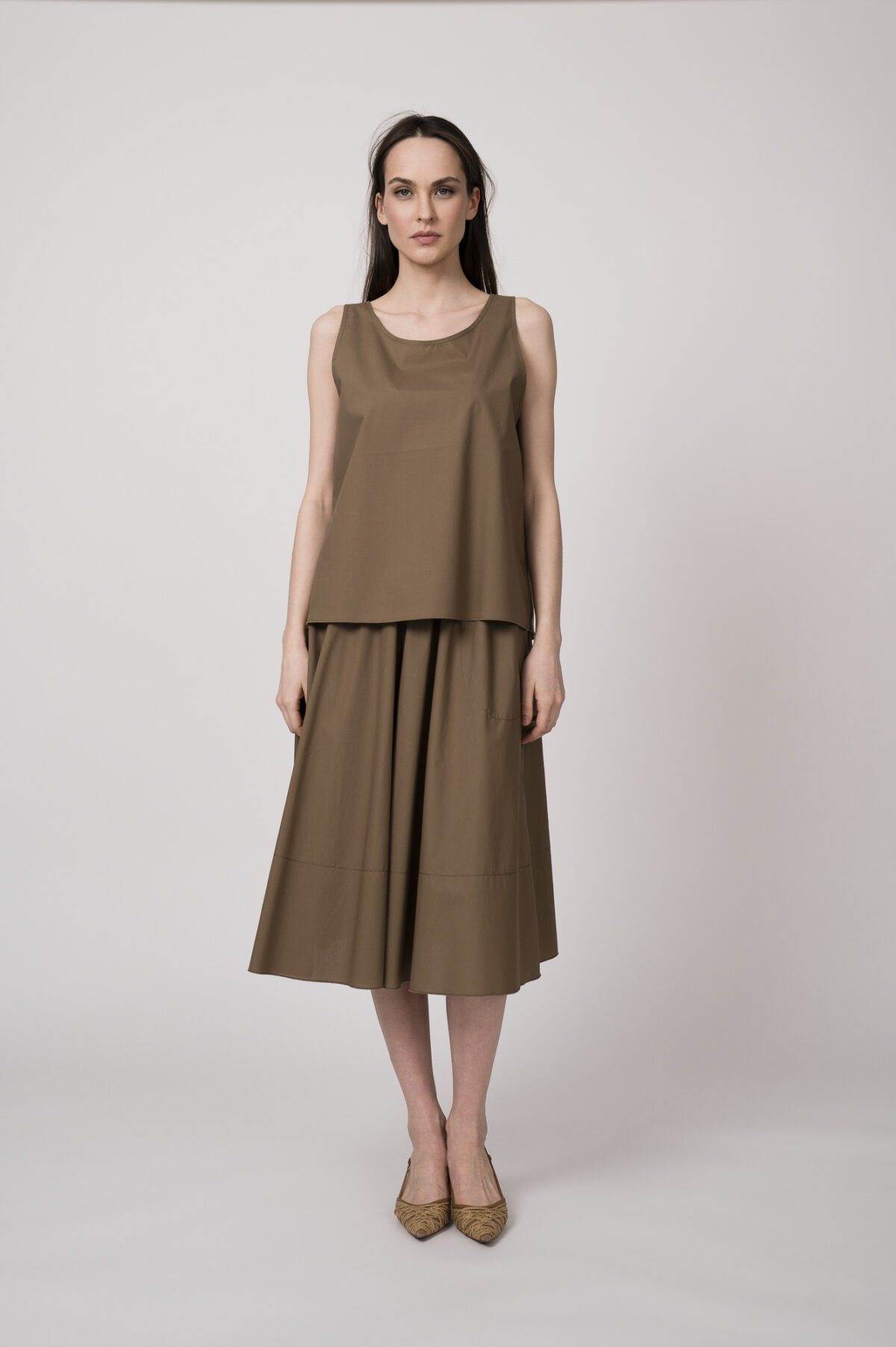 Model trägt ein schlamm-farbiges Top und einen schlamm-farbigen Rock der Marke Susanne Bommer.