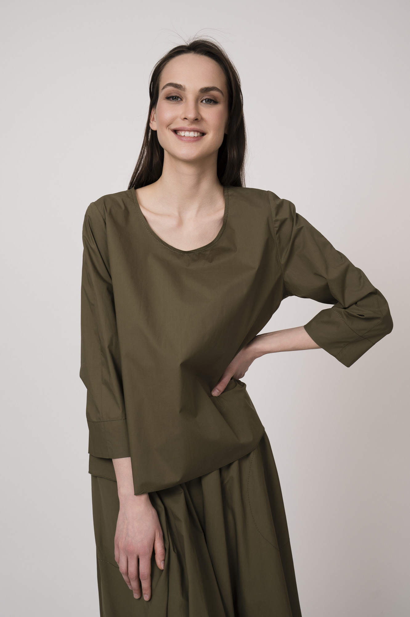 Model trägt eine olivgrüne Bluse der Marke Susanne Bommer.
