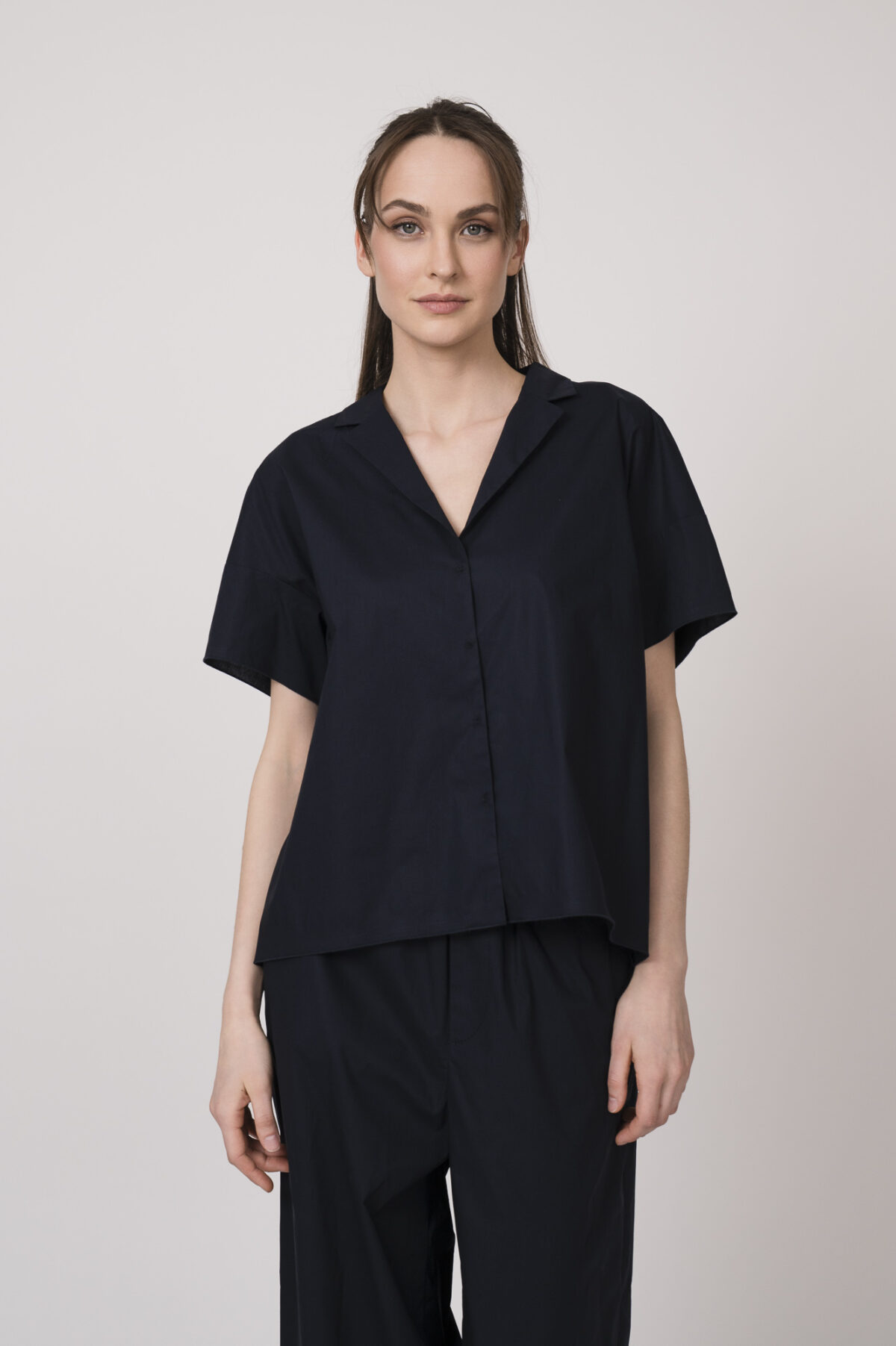 Model trägt eine marine-blaue Bluse der Marke Susanne Bommer.