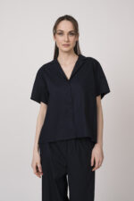 Model trägt eine marine-blaue Bluse der Marke Susanne Bommer.