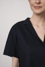 Model trägt eine marine-blaue Bluse der Marke Susanne Bommer.