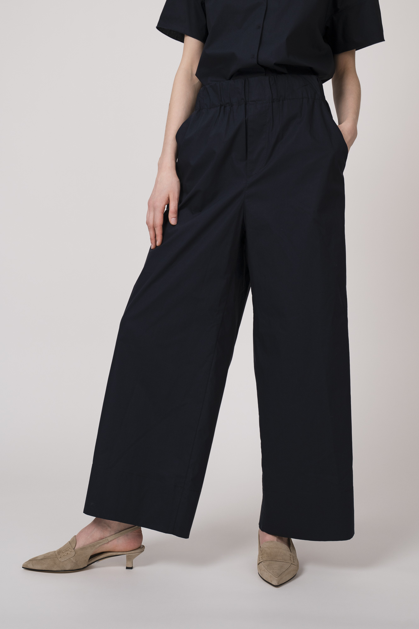 Model trägt eine marine-blaue Hose der Marke Susanne Bommer.