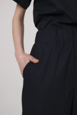 Model trägt eine marine-blaue Hose der Marke Susanne Bommer.