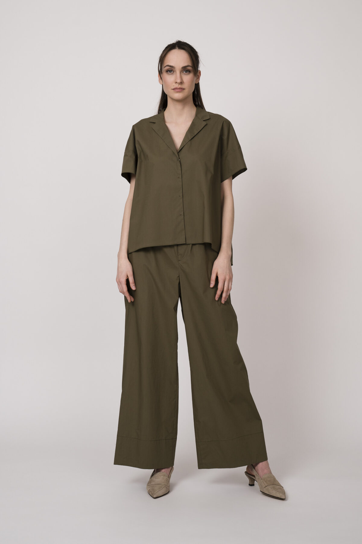 Model trägt eine olivgrüne Bluse und eine olivgrüne Hose der Marke Susanne Bommer.