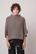 Model trägt einen grauen Kurzarm-Strickpullover der Marke FFC.