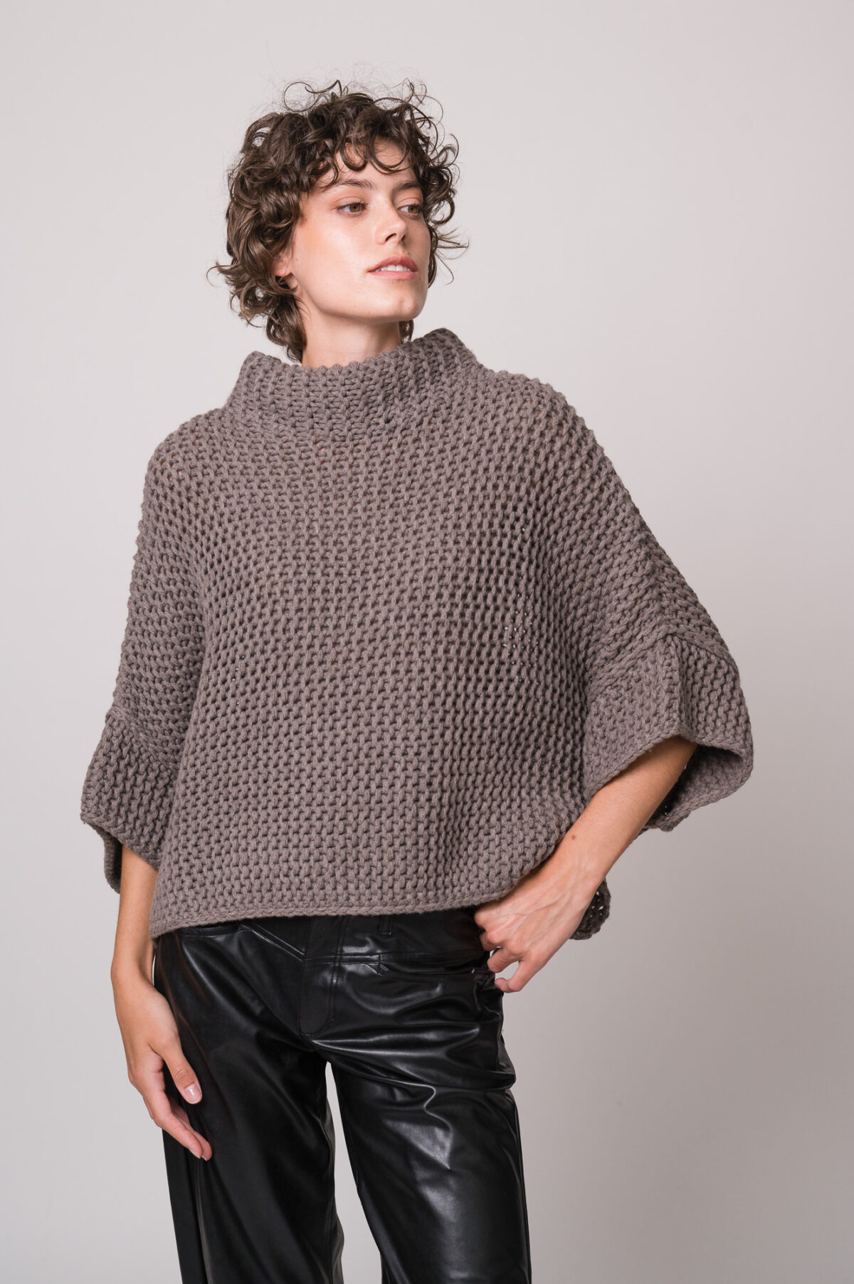 Model trägt einen grauen Kurzarm-Strickpullover der Marke FFC.