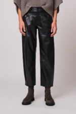 Model trägt eine schwarze Fake Lederhose der Marke Cambio.