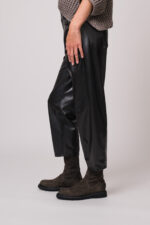 Model trägt eine schwarze Fake Lederhose der Marke Cambio.