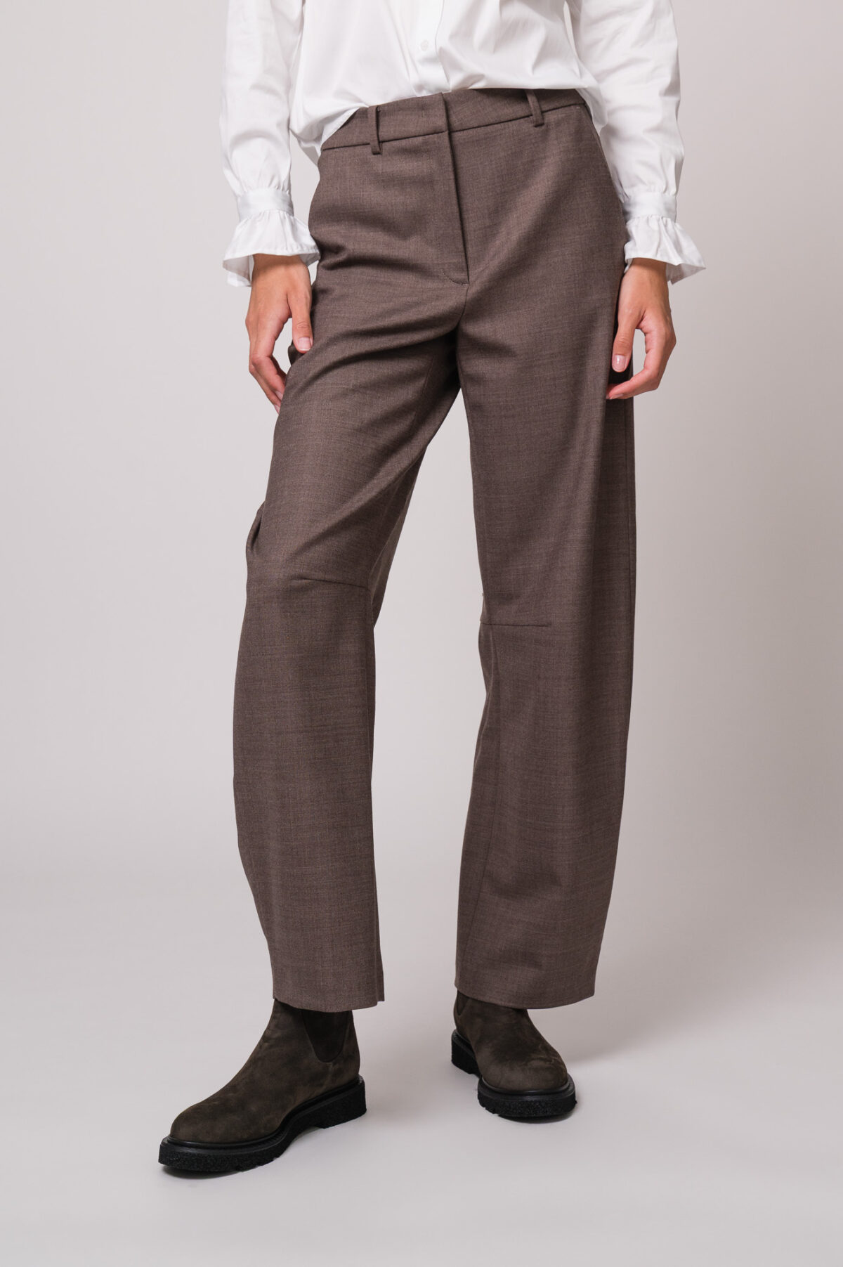 Model trägt eine braune Stoffhose der Marke Cambio.