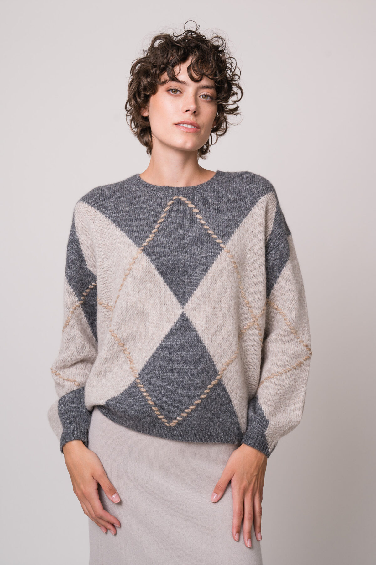 Model trägt einen grau gemusterten Pullover der Marke Luisa Cerano