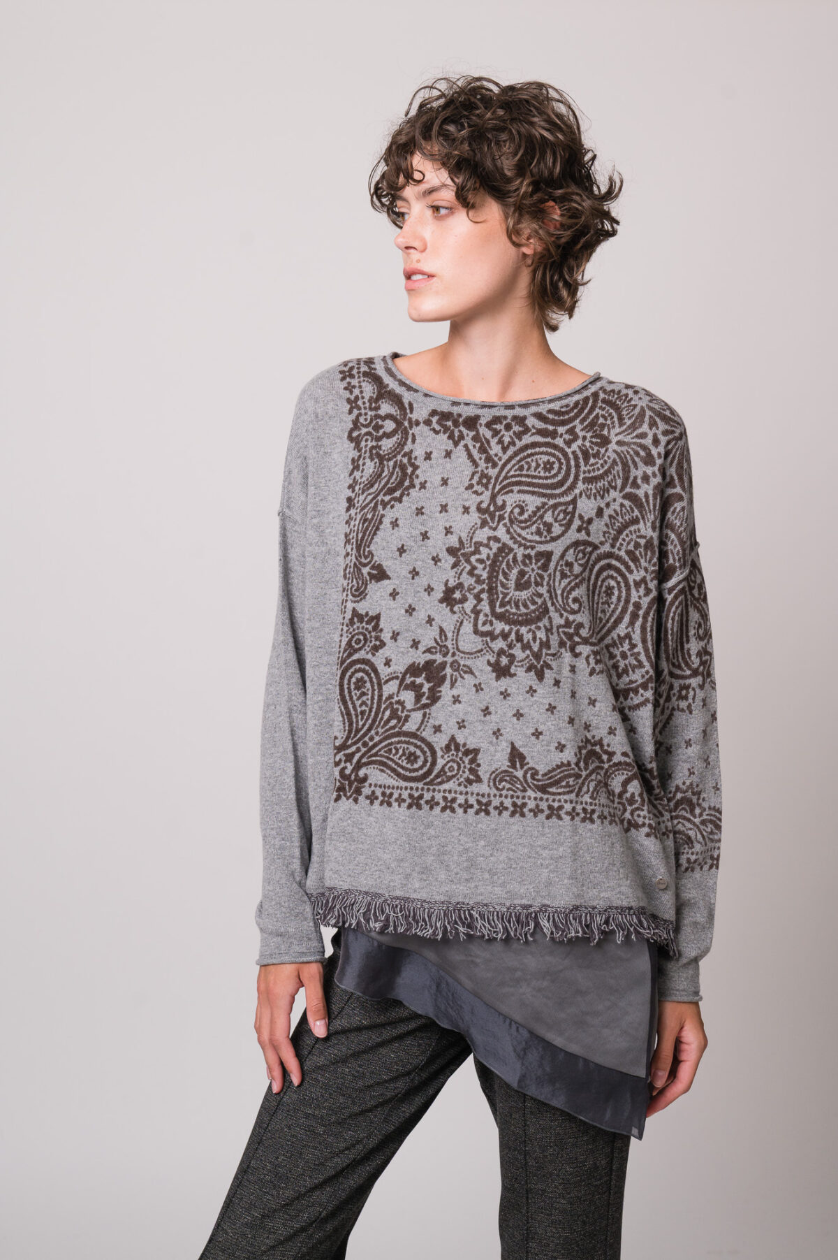 Model trägt ein graues Seidentop der Marke Luisa Cerano, einen grau gemusterten Pullover der Marke Grace.