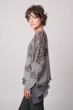 Model trägt ein graues Seidentop der Marke Luisa Cerano, einen grau gemusterten Pullover der Marke Grace.