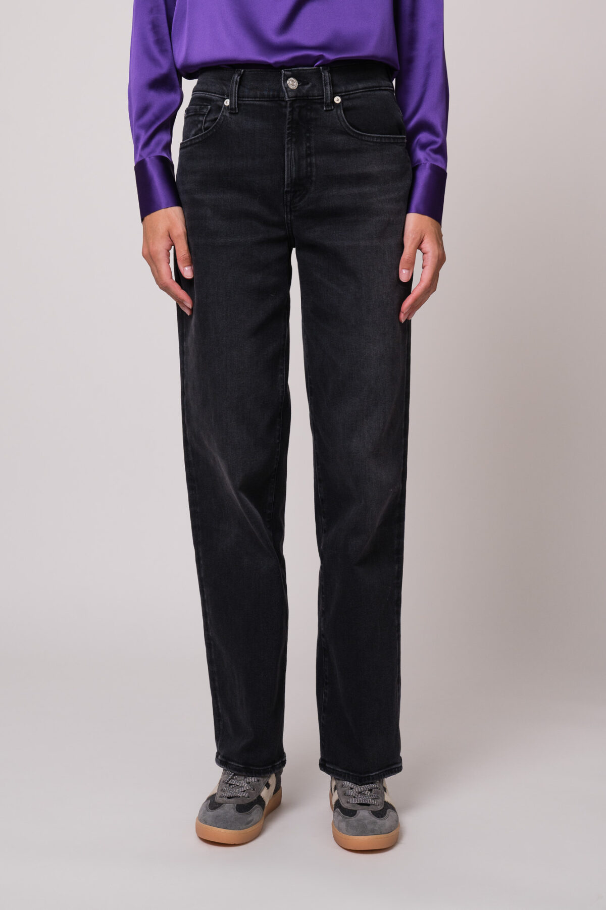 Model trägt eine schwarze Jeans der Marke 7 for all mankind