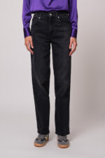 Model trägt eine schwarze Jeans der Marke 7 for all mankind
