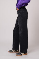 Model trägt eine schwarze Jeans der Marke 7 for all mankind