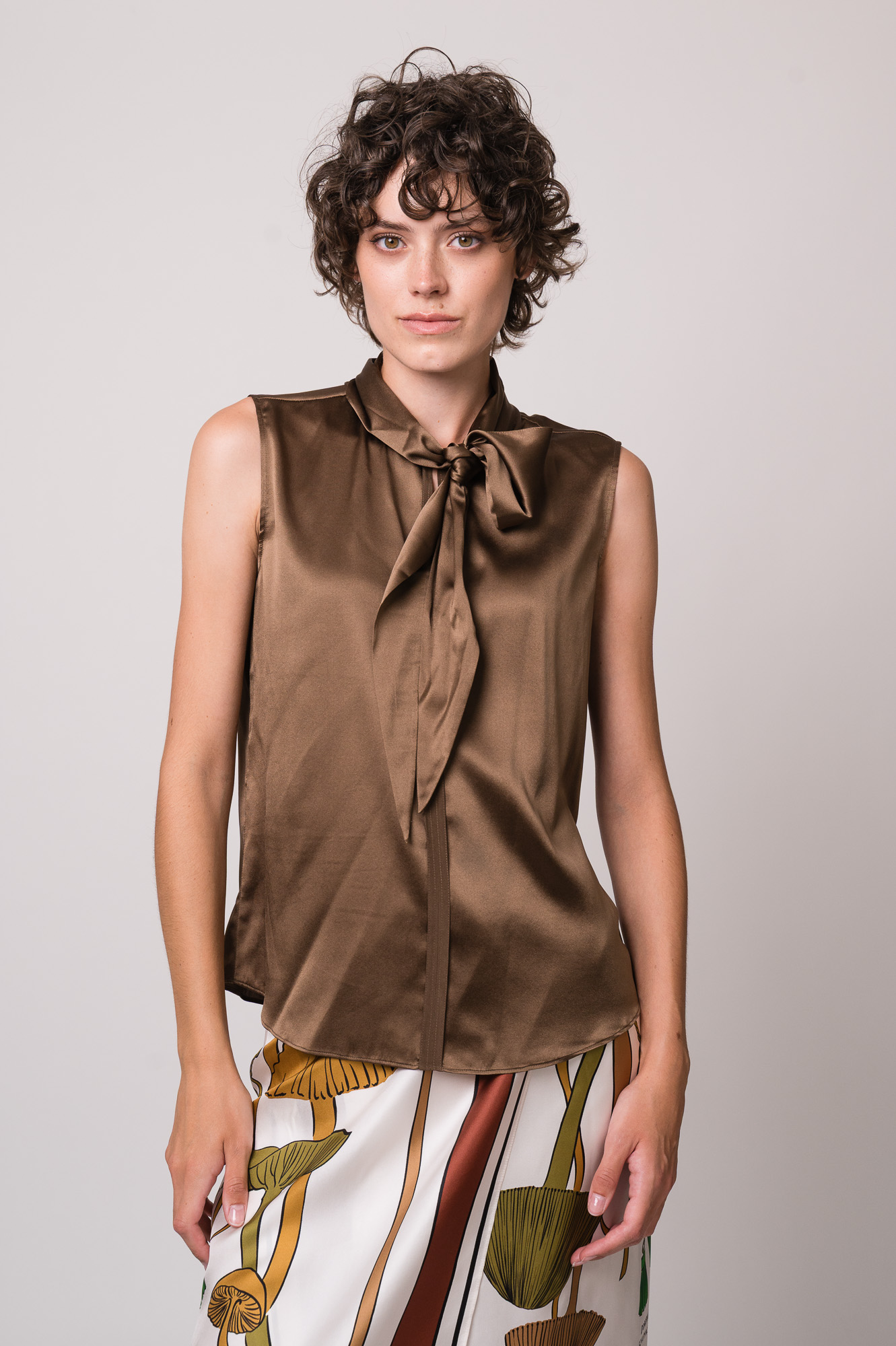 Model trägt eine braune Bluse und einen gemusterten Rock der Marke Dorothee Schumacher.