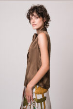 Model trägt eine braune Bluse und einen gemusterten Rock der Marke Dorothee Schumacher.