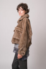 Model trägt eine braune Fake Fur Jacke der Marke Betta Corradi, ein graues Seidentop der Marke Luisa Cerano, einen grau gemusterten Pullover der Marke Grace.