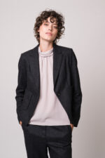 Model trägt eine helle Bluse, einen grauen Blazer und eine graue Hose der Marke Luisa Cerano.