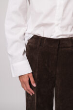 Model trägt eine braune Kordhose der Marke Cambio