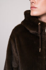 Model trägt eine dunkelbraune Jacke der Marke Mabrun