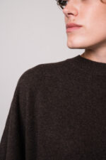 Model trägt einen braunen Pullover der Marke Herzens
