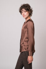 Model trägt eine braune Bluse der Marke The Mercer