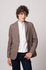 Model trägt einen braun karierten Blazer der Marke Circolo, eine weiße Bluse der Marke Wendy Stark und eine blaue Jeans der Marke True Religion