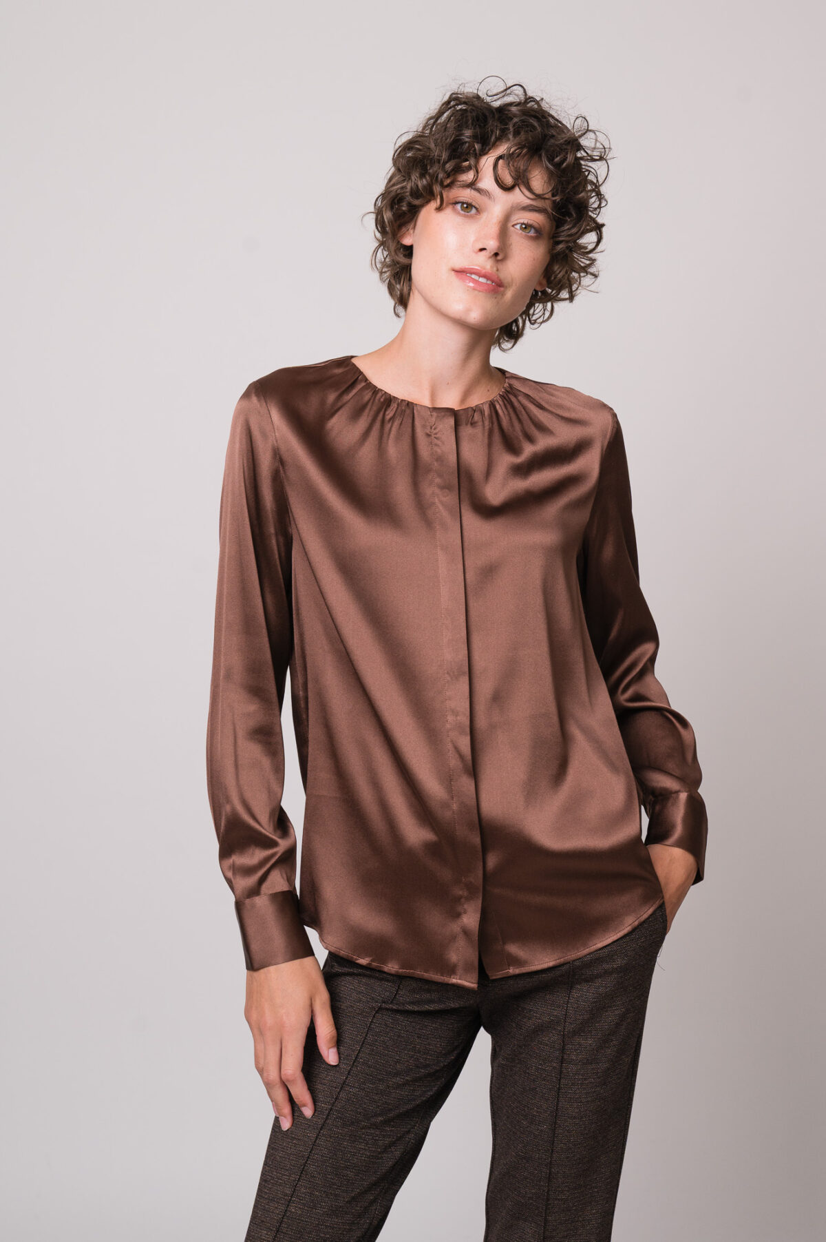 Model trägt eine braune Bluse der Marke The Mercer