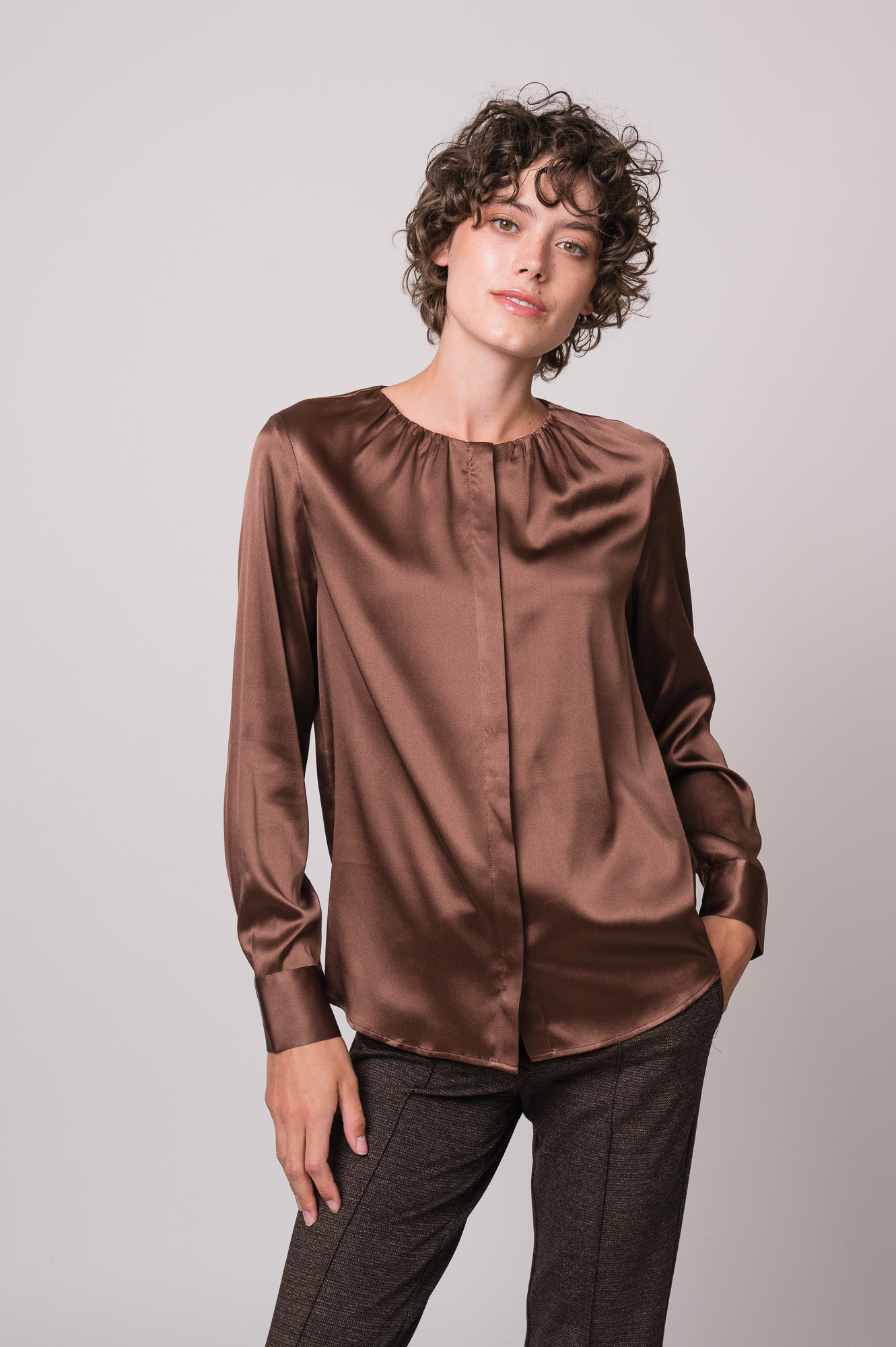 Model trägt eine braune Bluse der Marke The Mercer
