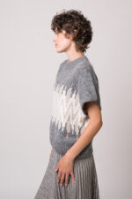 Model trägt eine grau gemusterten Pullover der Marke Joop