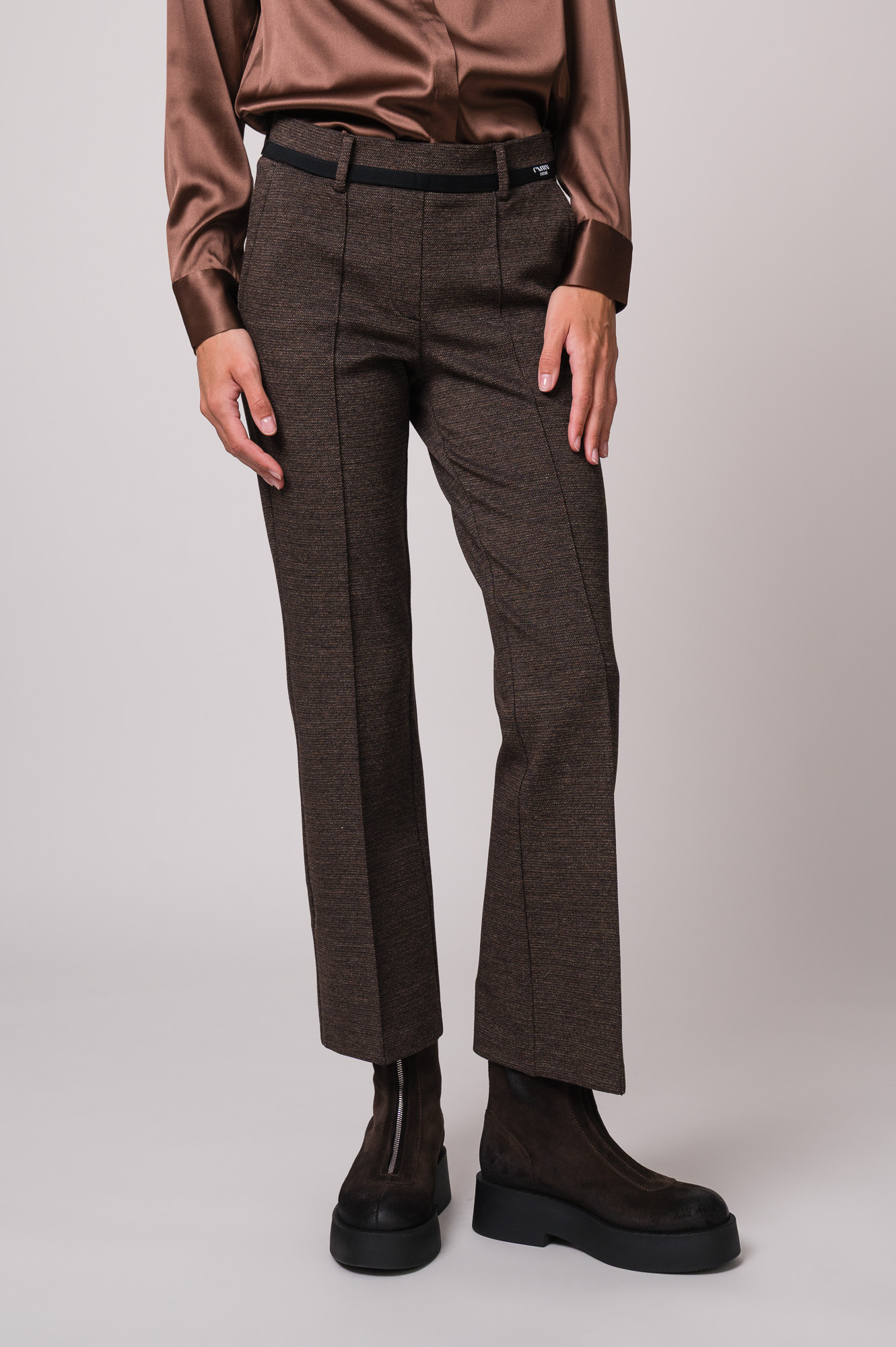 Model trägt eine braune Hose der Marke Cambio.