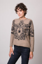 Model trägt einen beige gemusterten Pullover der Marke Grace.