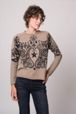 Model trägt einen beige gemusterten Pullover der Marke Grace.