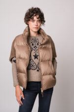Model trägt ein beiges Cape der Marke Mabrun und einen beige gemusterten Pullover der Marke Grace.