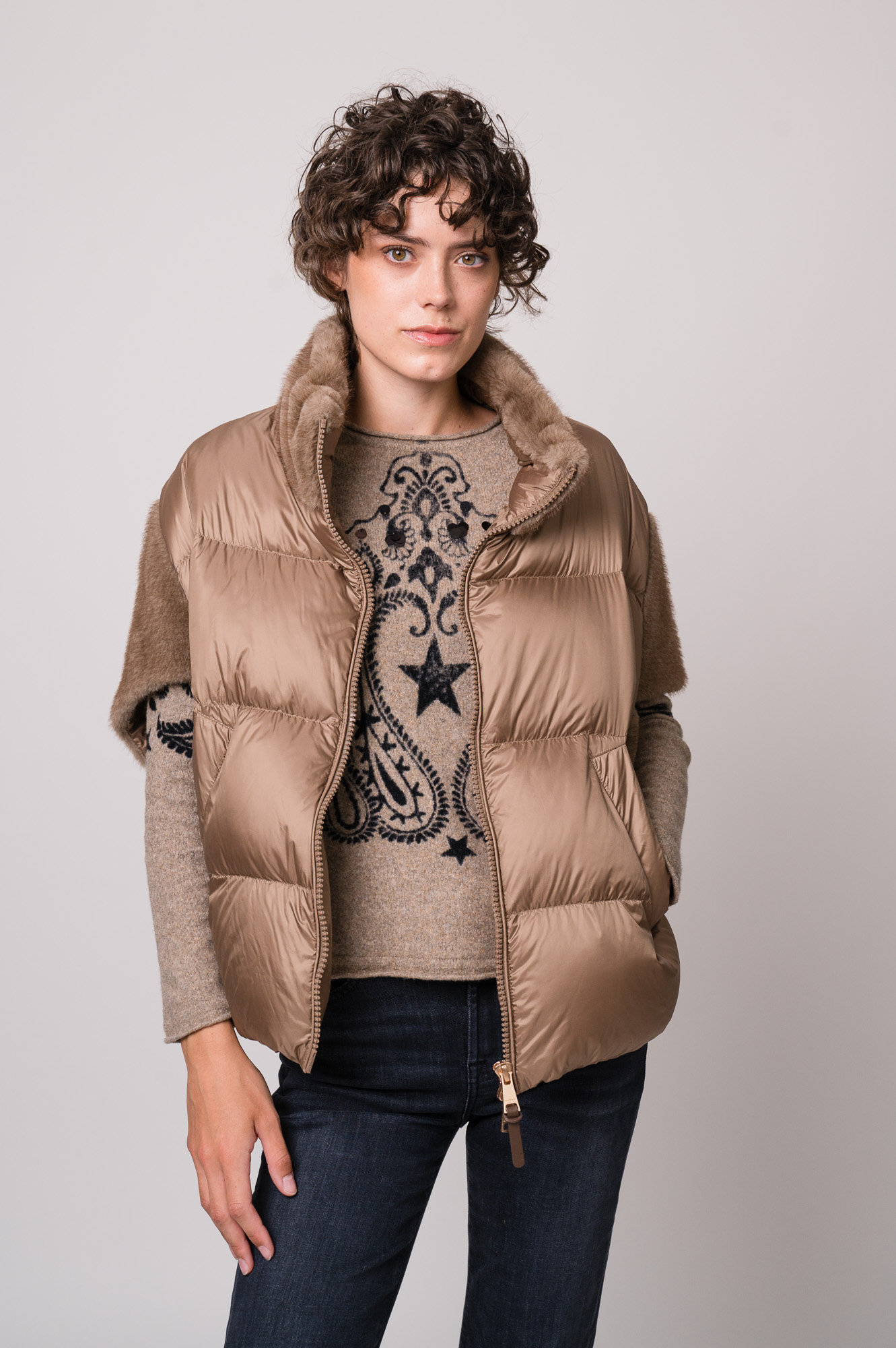 Model trägt ein beiges Cape der Marke Mabrun und einen beige gemusterten Pullover der Marke Grace.