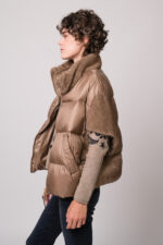 Model trägt ein beiges Cape der Marke Mabrun und einen beige gemusterten Pullover der Marke Grace.