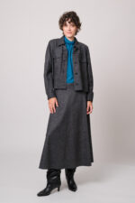 Model trägt eine graue Blazerjacke und einen grauen Rock sowie eine türkisblaue Bluse der Marke Luisa Cerano.