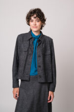 Model trägt eine graue Blazerjacke und eine türkisblaue Bluse der Marke Luisa Cerano.